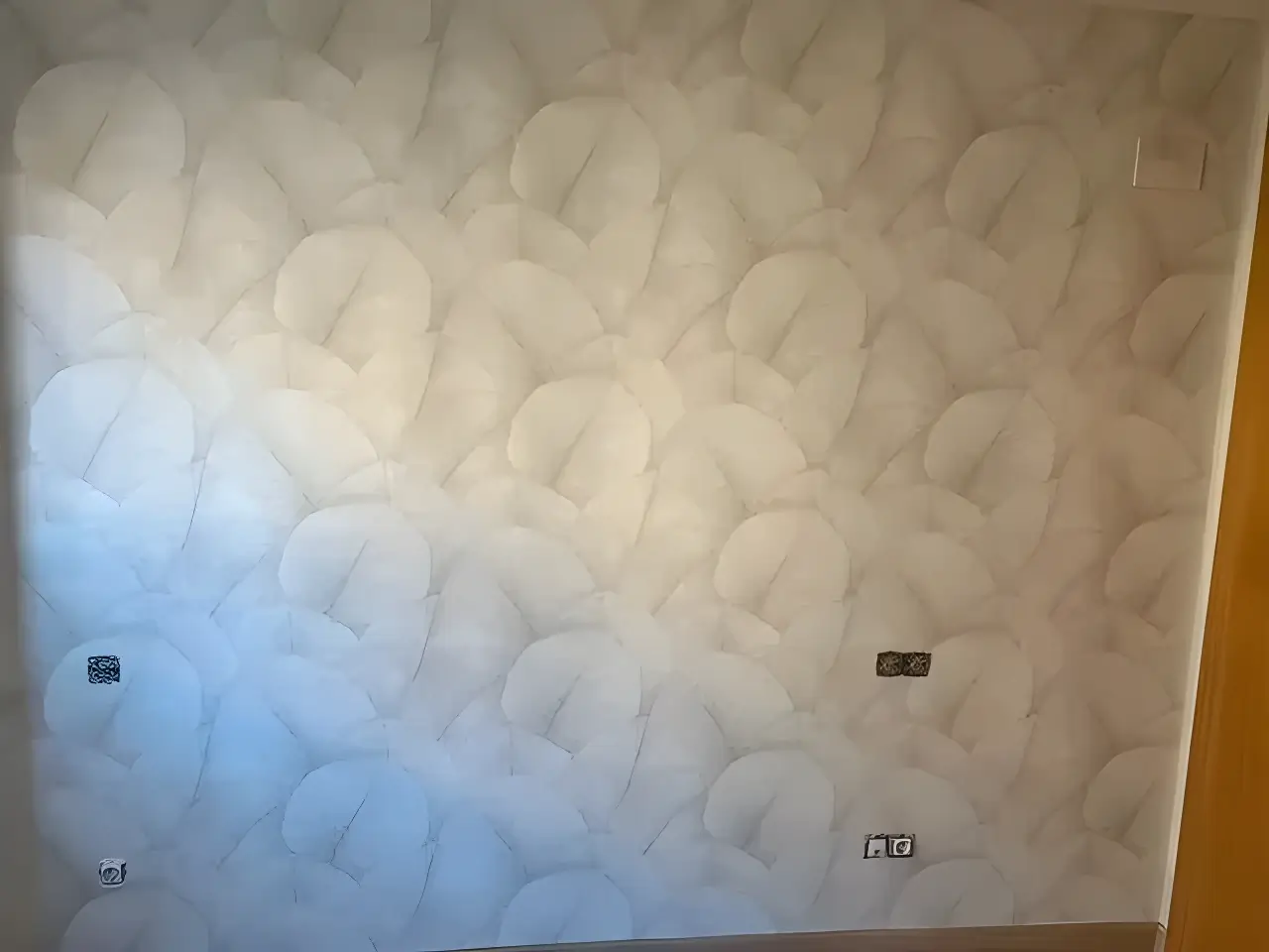 Pintor en Cartagena aplicando papel pintado de textura clara en salón reformado